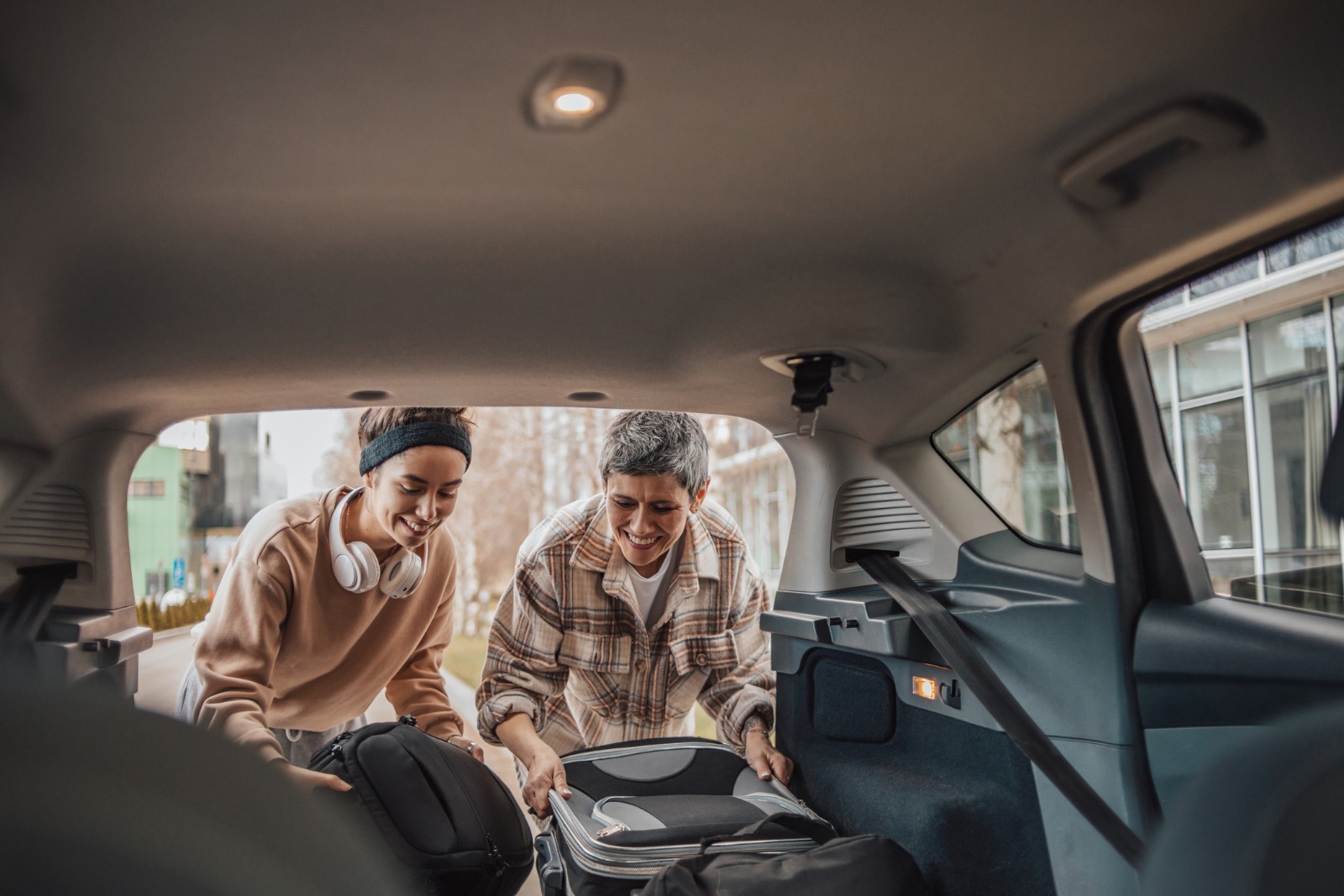 Mother and daughter pack their bags in the car
