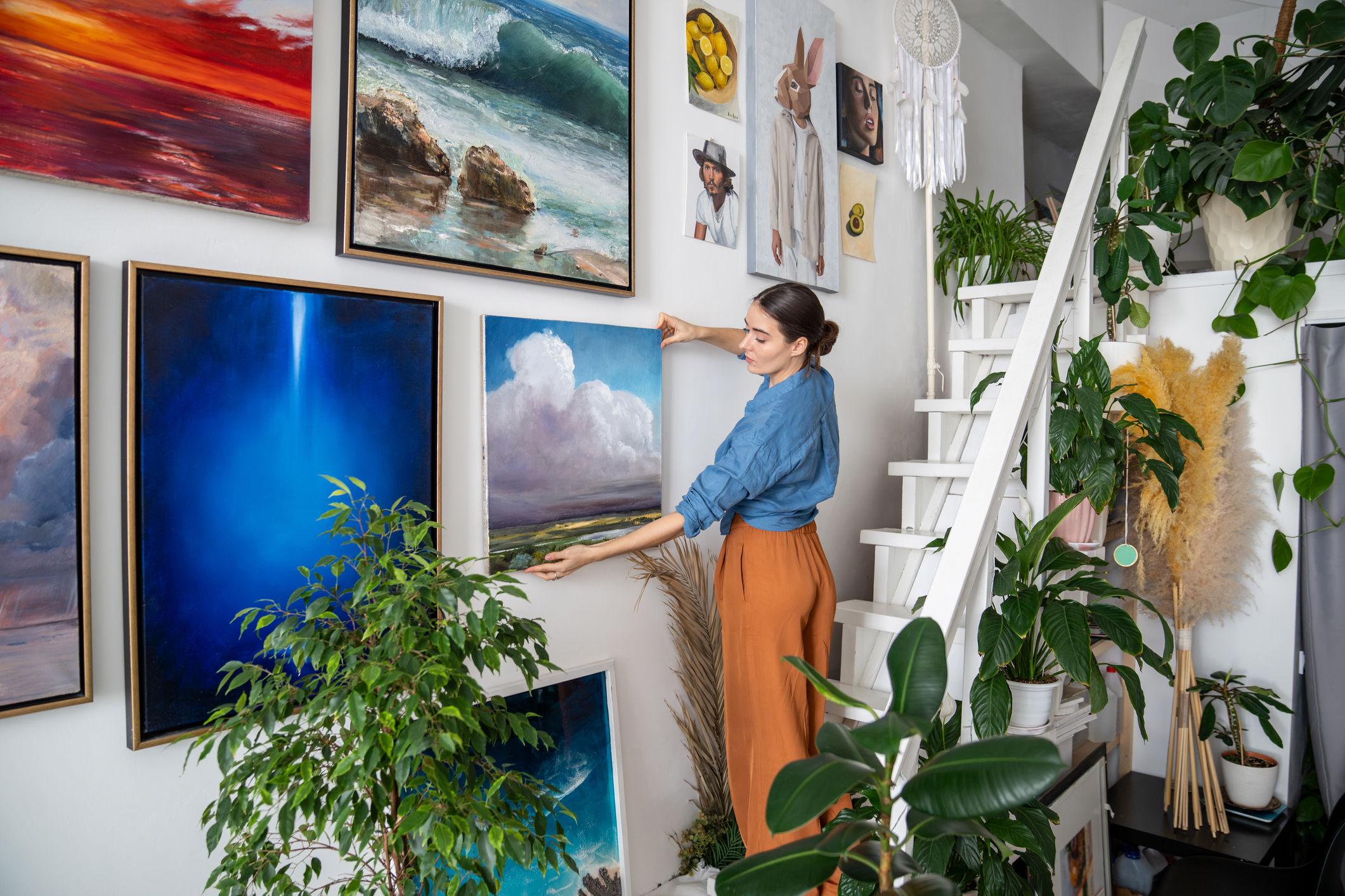woman artist hanging paintings